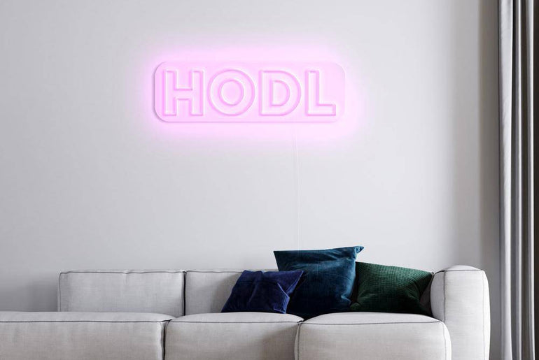 HODL Neonschild in Rosa über weißem Sofa