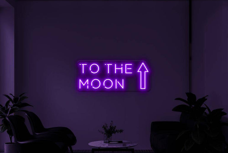 Lila LED-Neonschild 'TO THE MOON' in dunklem Raum