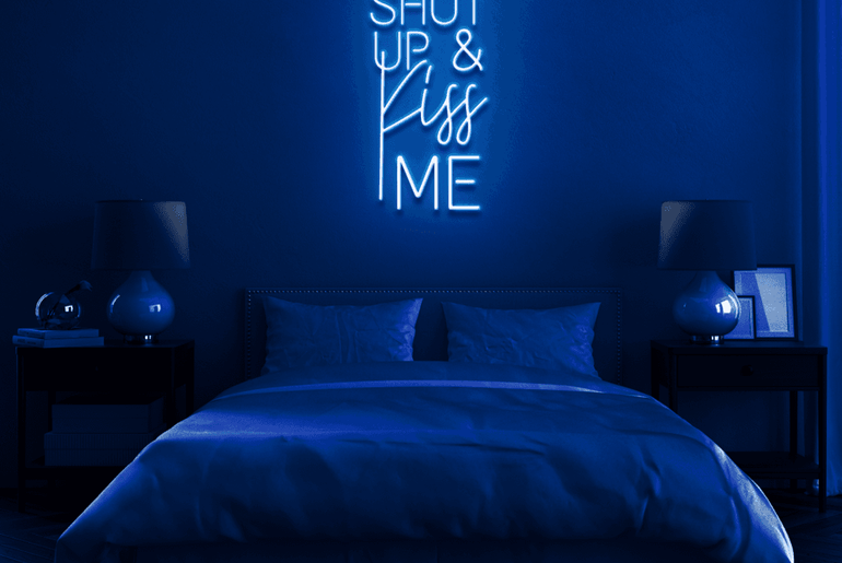 Blaues 'SHUT UP AND KISS ME' LED-Neonschild im Schlafzimmer